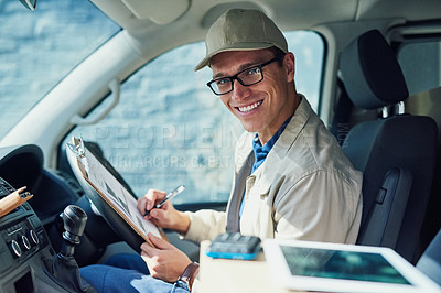 Buy stock photo Portrait of a courier writing on a clipboard while sitting in a delivery van
