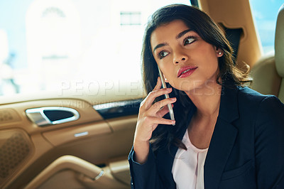 Buy stock photo Shot of an attractive young woman on a call in a car