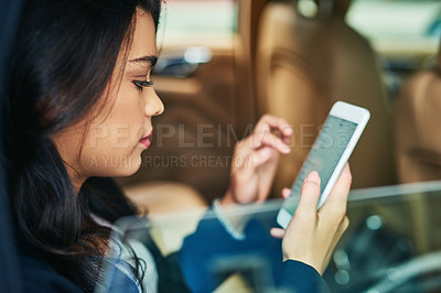 Buy stock photo Shot of an attractive young woman using a cellphone in a car