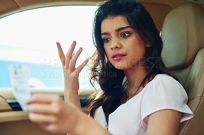 Buy stock photo Shot of an attractive young woman annoyed that she got a traffic ticket