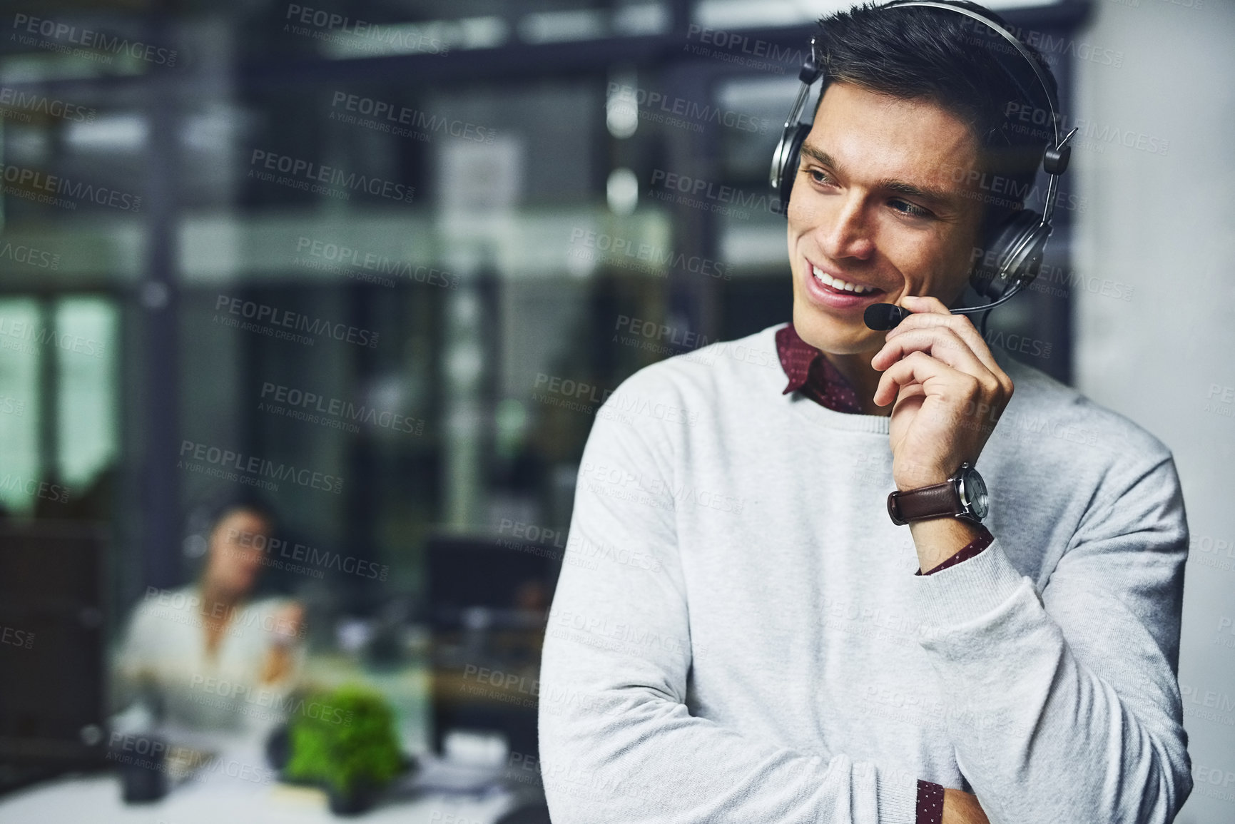 Buy stock photo Shot of a young call centre agent working late in an office