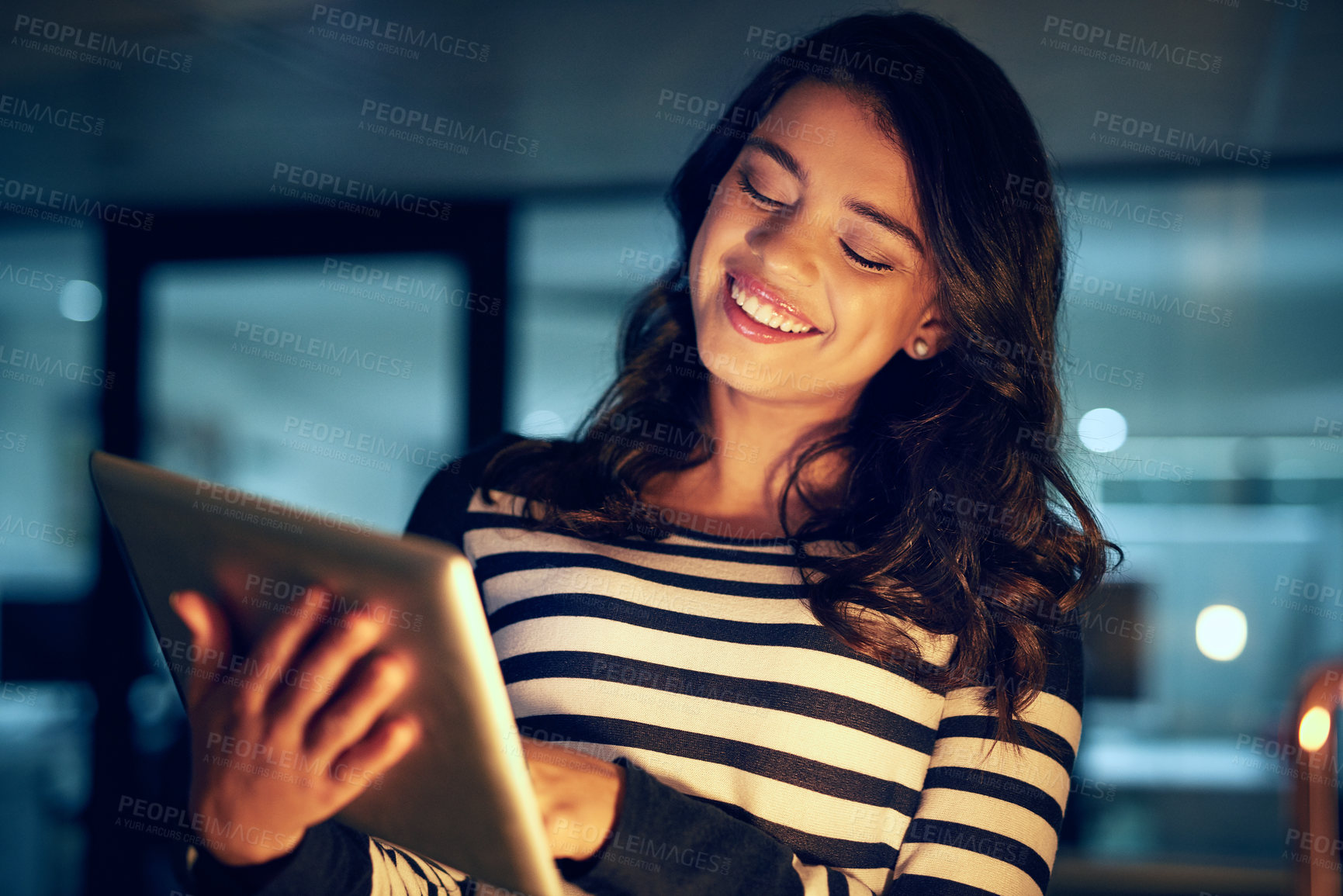 Buy stock photo Woman, office and smile with tablet at night for overtime for deadline of product innovation, research and planning. Girl, internet and working late for prototype development, features and design.