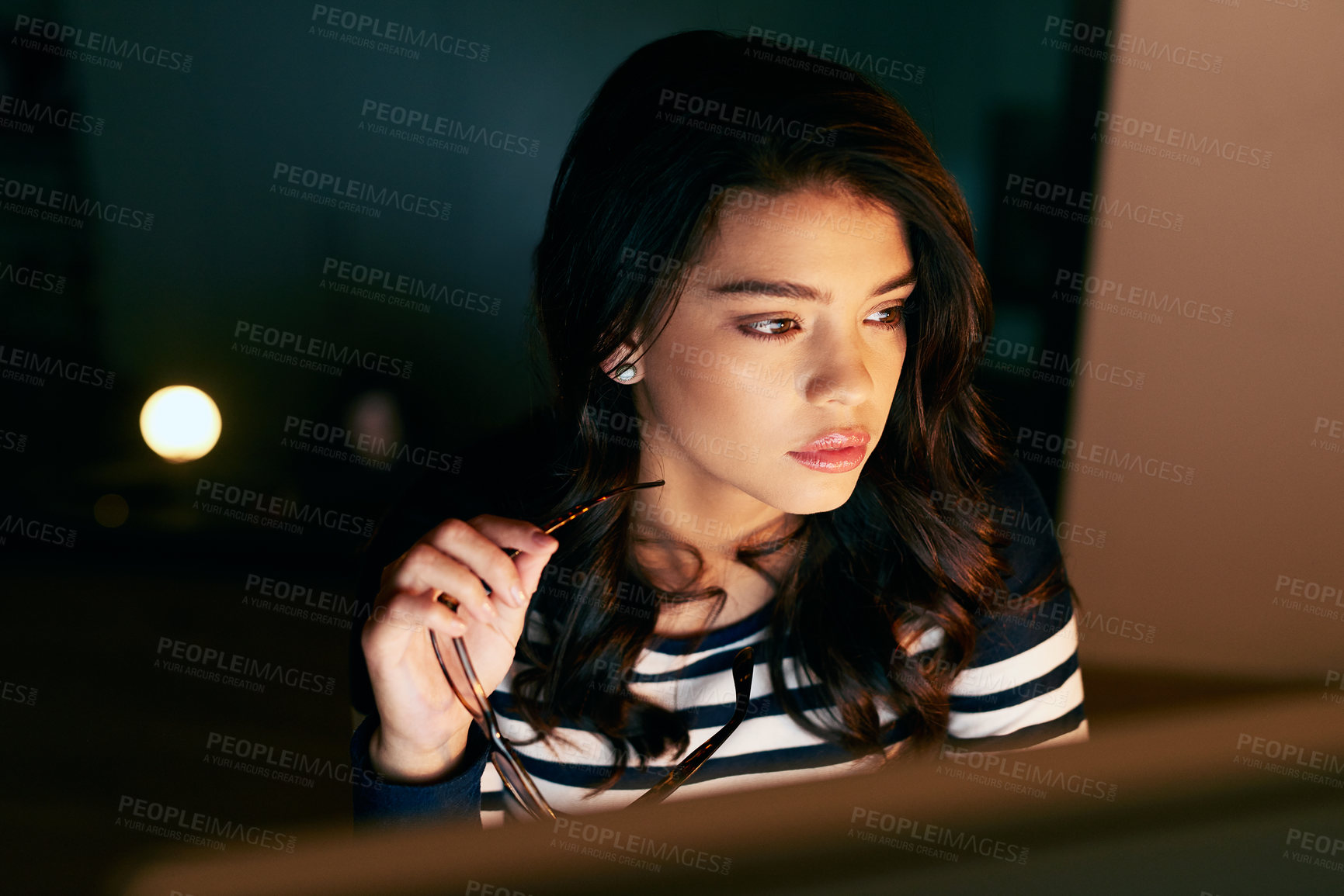 Buy stock photo Shot of a young businesswoman working late in an office