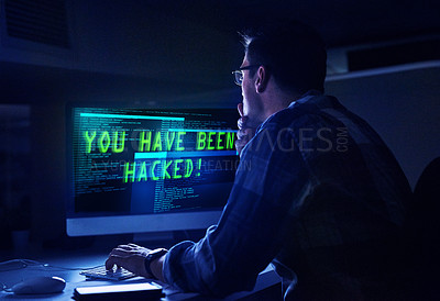 Buy stock photo Rearview shot of a young male hacker at work