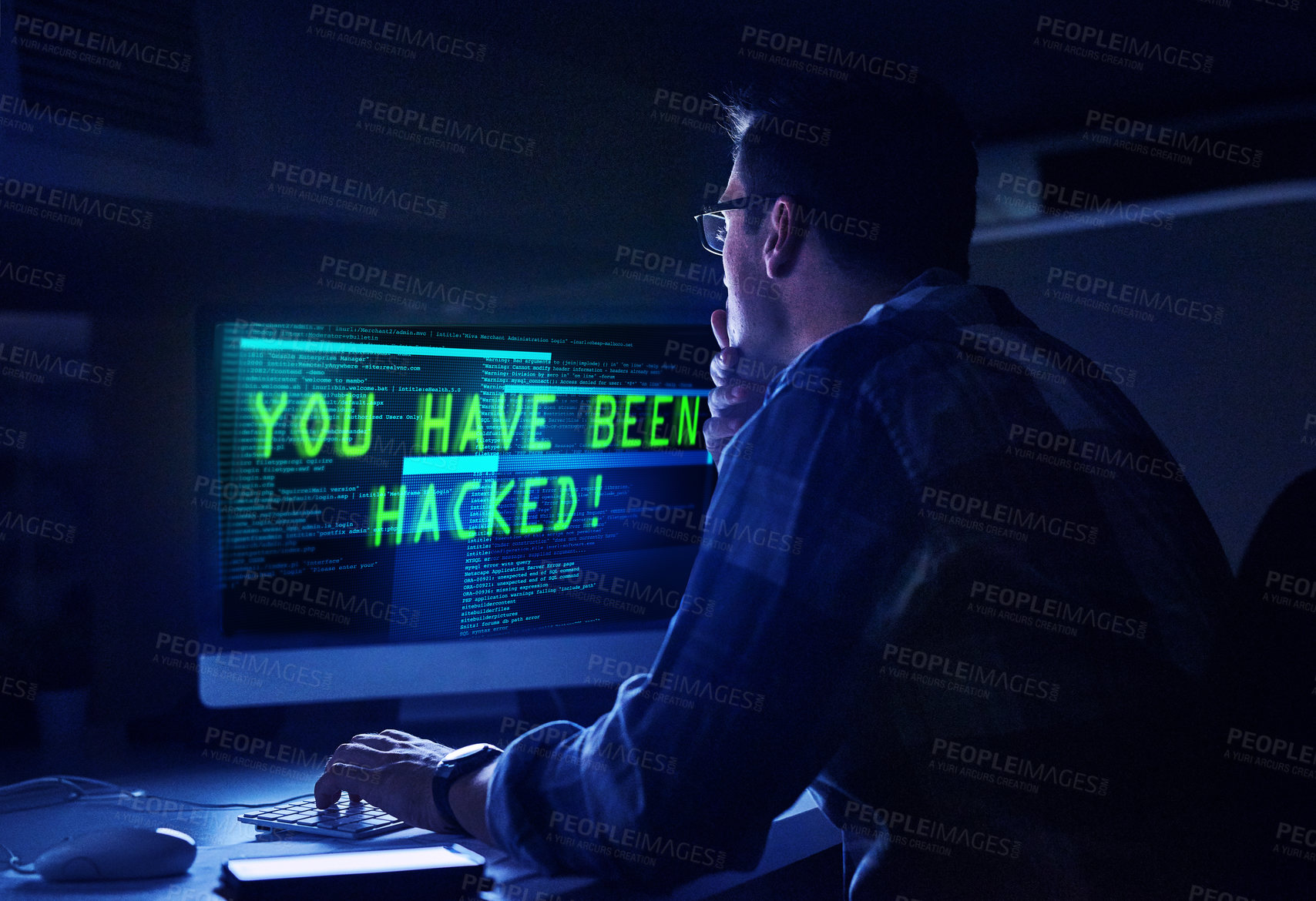 Buy stock photo Rearview shot of a young male hacker at work