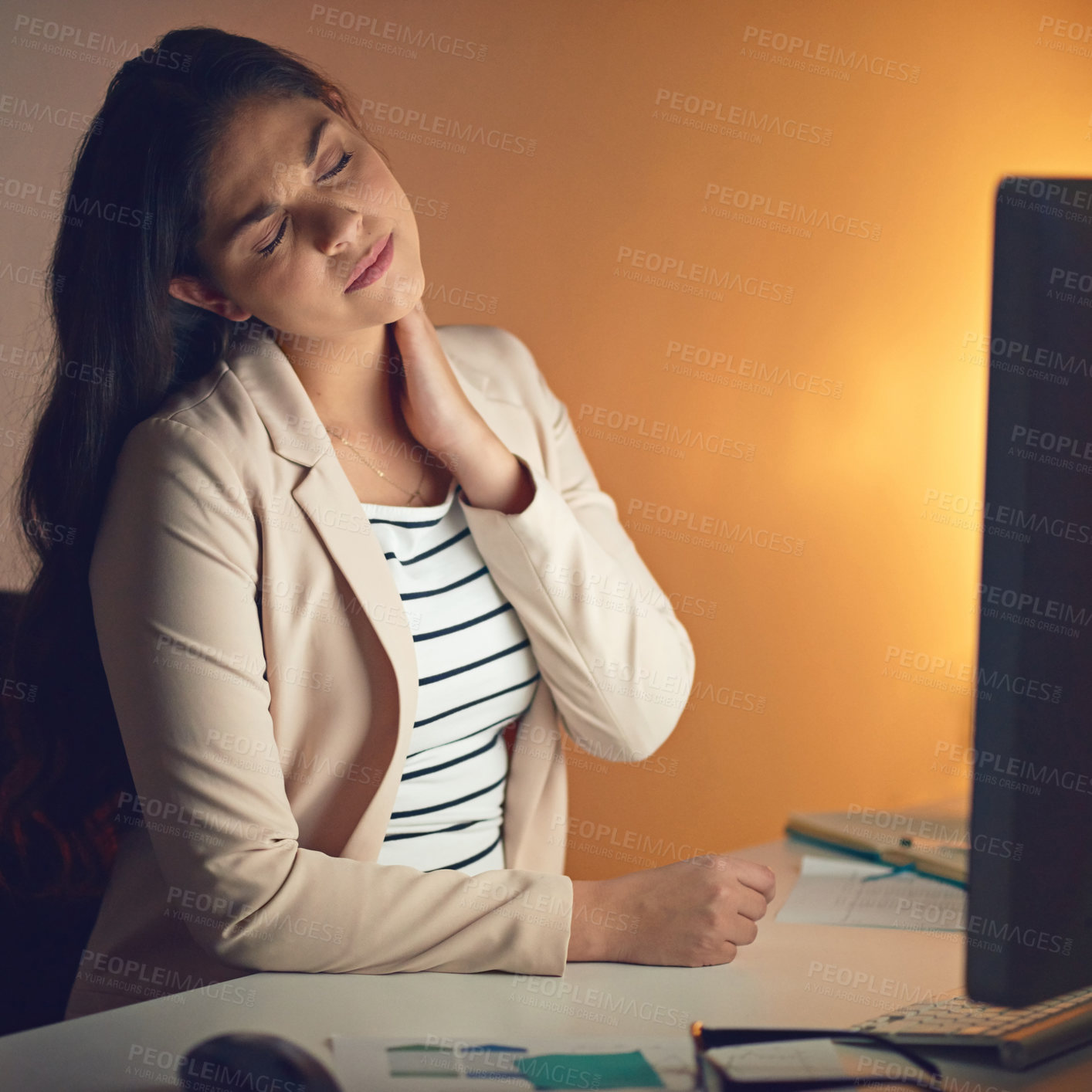 Buy stock photo Shot of a young businesswoman experiencing strain during a late night at work