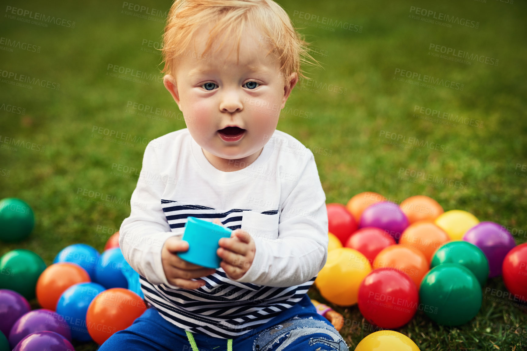 Buy stock photo Portrait, colourful balls and baby in backyard, relax and playful with fun, happiness and calm. Face, infant and toddler on grass, garden and carefree with peace, kid and childhood with nature