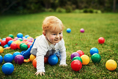 Buy stock photo Baby, grass and playing with balls outdoor in park or backyard for motor skills and early childhood development. Happy child on floor crawling with colorful toys for holiday, fun and learning on lawn