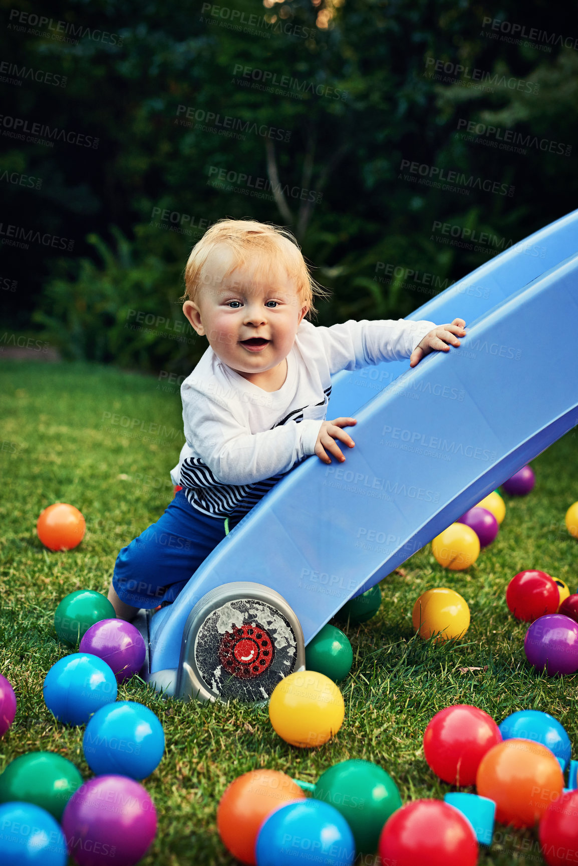 Buy stock photo Game, colourful balls and baby in backyard, relax and playful with fun, happiness and calm. Smile, infant and toddler on grass, cheerful and carefree with motor skills, kid and childhood with nature