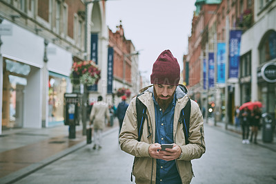 Buy stock photo Walking, street and phone of man with search, direction and travel in London on vacation. Location app, tourist and journey with navigation, text and digital guide for holiday in city with mobile