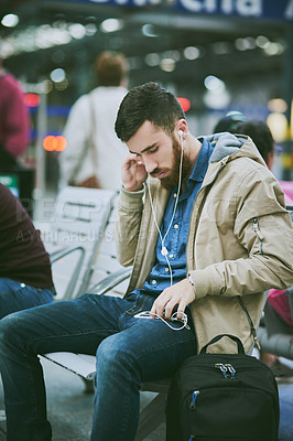 Buy stock photo Travel, earphones and man with phone at airport for music, streaming subscription and radio. International trip, commute and person waiting on smartphone for listening to song, audio and podcast