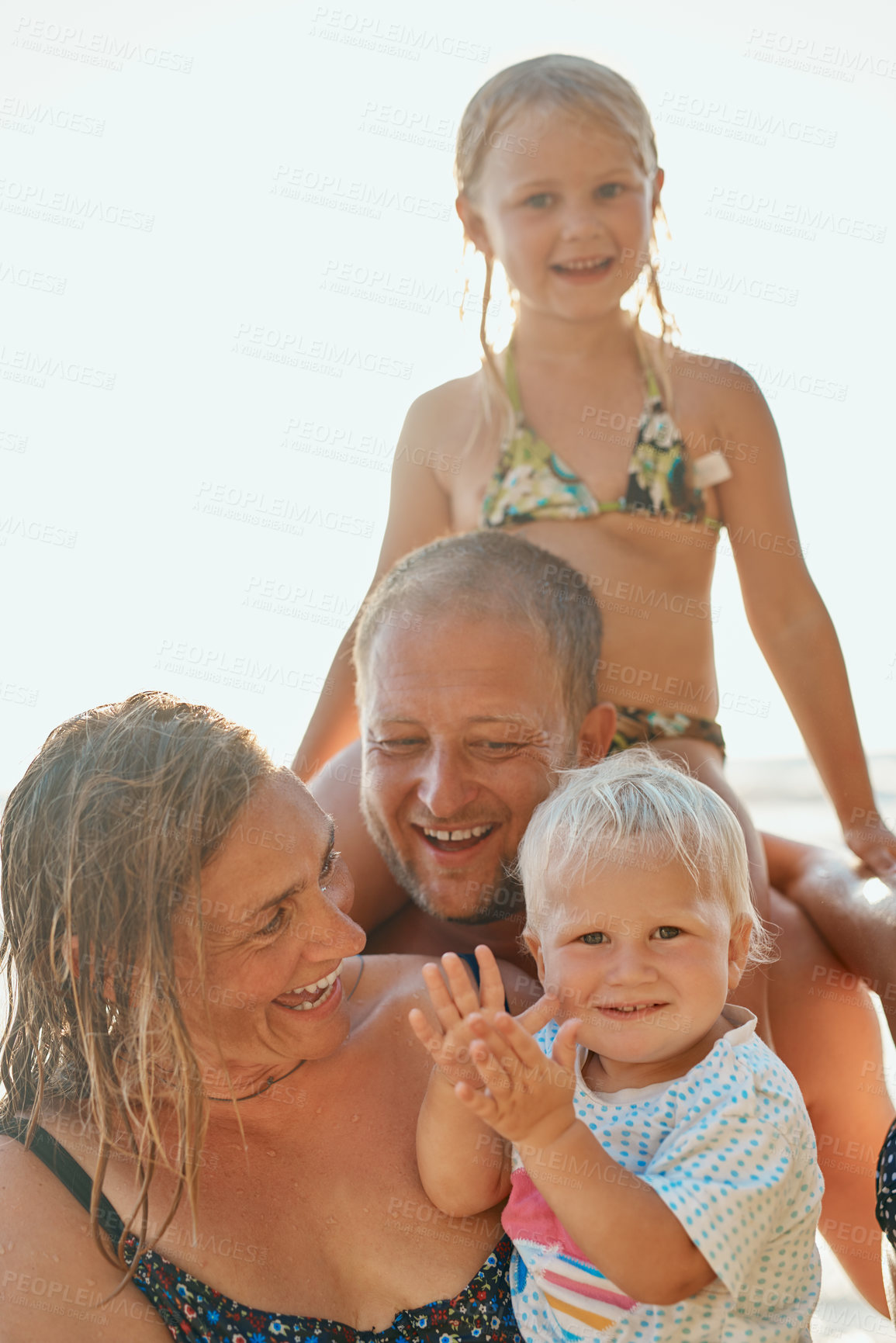 Buy stock photo Cropped shot of a couple and their two kids spending the day at the beach