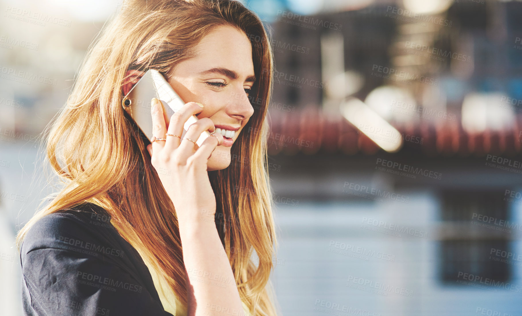 Buy stock photo Cropped shot of an attractive young woman making a phone call while standing outside