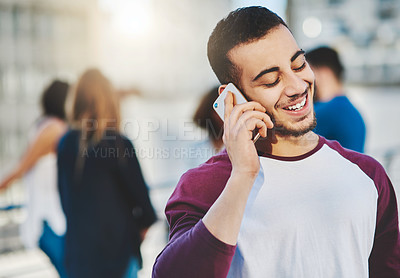 Buy stock photo Cropped shot of a handsome young man making a phone call while standing outside