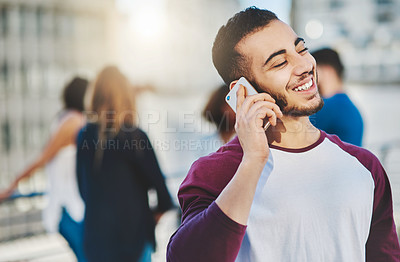 Buy stock photo Cropped shot of a handsome young man making a phone call while standing outside