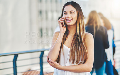 Buy stock photo Cropped shot of an attractive young woman making a phone call while standing outside