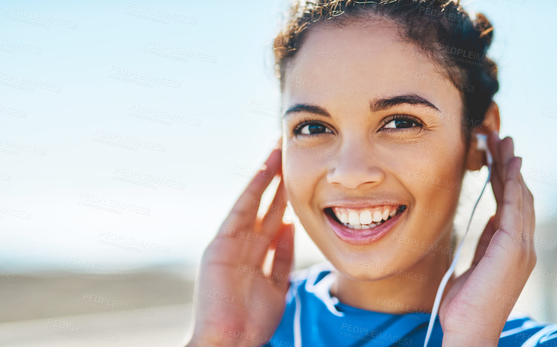 Buy stock photo Portrait of a sporty young woman listening to music while exercising outdoors
