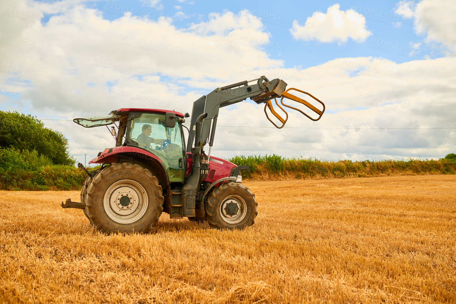 Buy stock photo Farming, man and tractor in field for care, ground maintenance and hay in countryside. Person, harvest machine and driving on California crops for gathering, animal feed and agriculture in USA