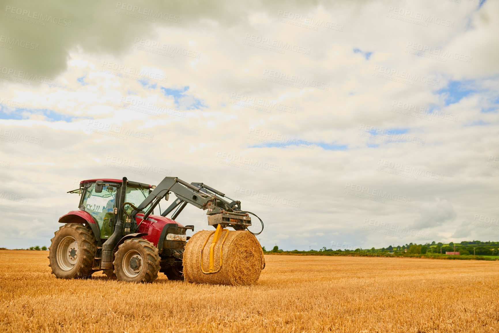 Buy stock photo Shot of a farmer stacking hale bales with a tractor on his farm