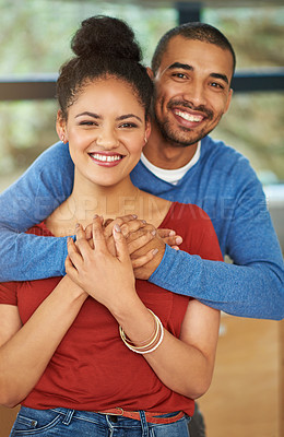Buy stock photo Cropped portrait of a handsome young man embracing his girlfriend in the kitchen