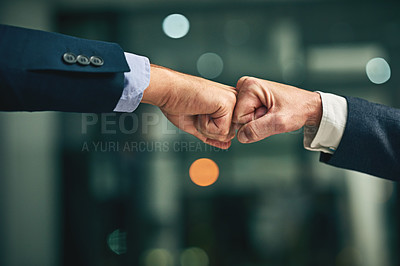 Buy stock photo Closeup shot of two unidentifiable businessmen fist bumping in an office