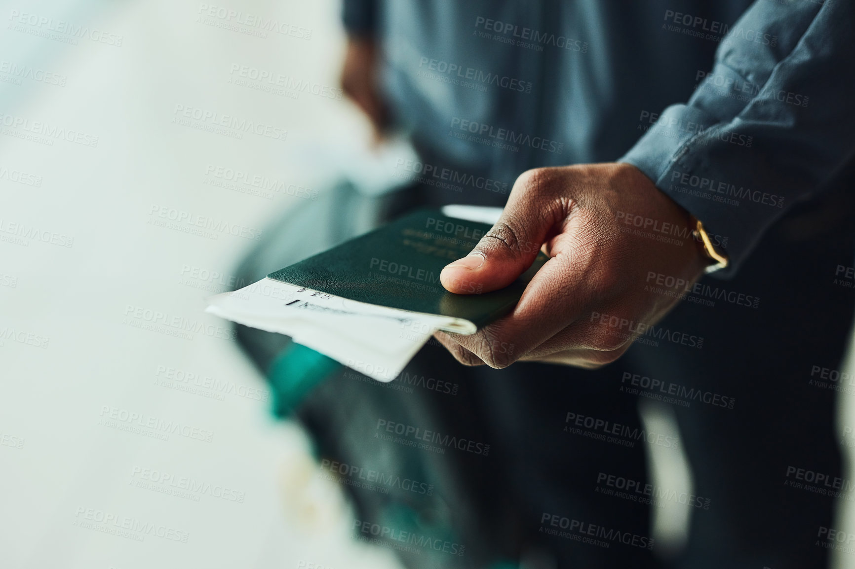 Buy stock photo Shot of an unrecognizable person holding his passport indoors