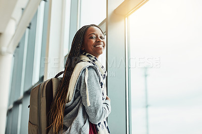 Buy stock photo Cropped shot of a young woman looking at out the airport window while waiting for departure