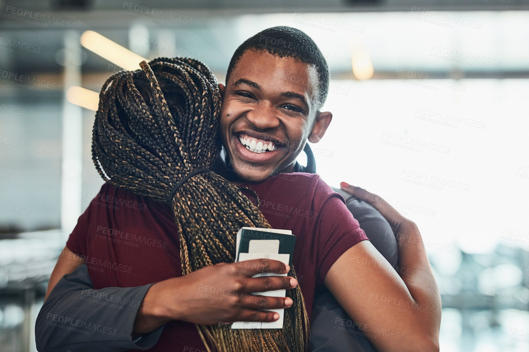 Buy stock photo Cropped portrait of a young man hugging his girlfriend at the airport