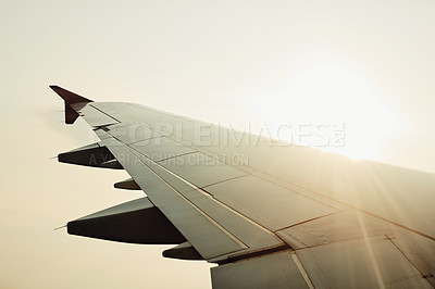 Buy stock photo Cropped shot of an airplane’s wing in mid flight