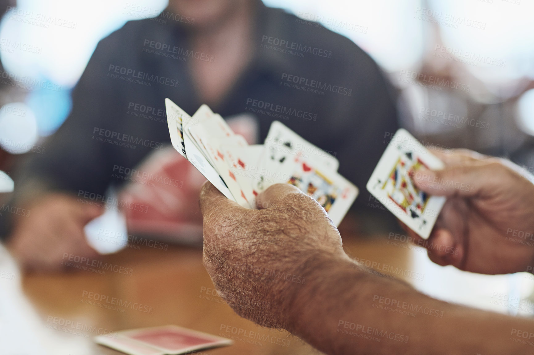 Buy stock photo Cropped shot of seniors playing poker in their retirement home