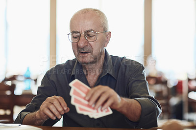 Buy stock photo Card, game and senior man in retirement home with care, playing and fun on table. Cognitive, memory and elderly activity in group with calm hobby, relax and poker for brain engagement and support