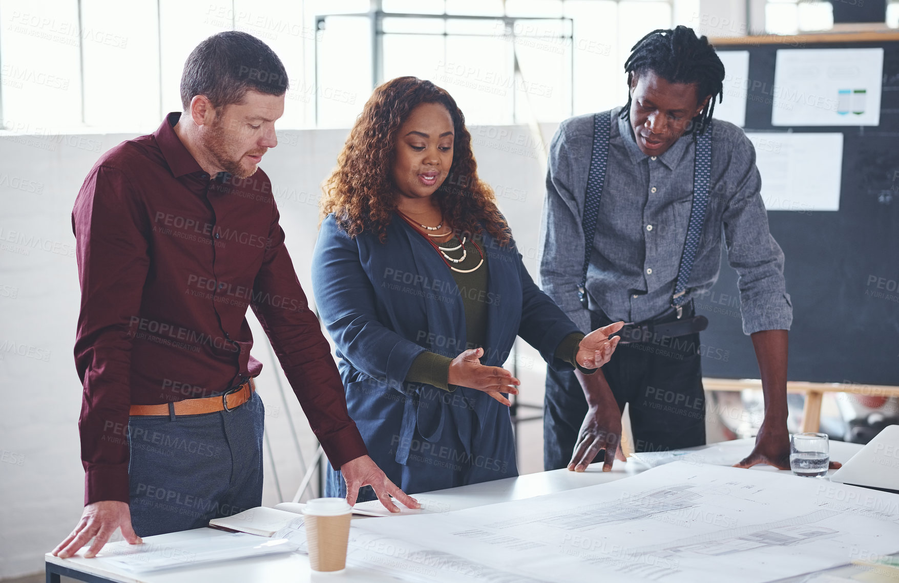 Buy stock photo Cropped shot of a team of professionals working on blueprints in an office