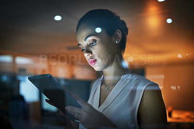 Buy stock photo Shot of a young businesswoman using a tablet in the office at night 