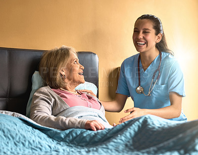 Buy stock photo Shot of a female nurse chatting to her senior patient