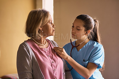 Buy stock photo Cropped shot of a nurse examining a senior patient with a stethoscope