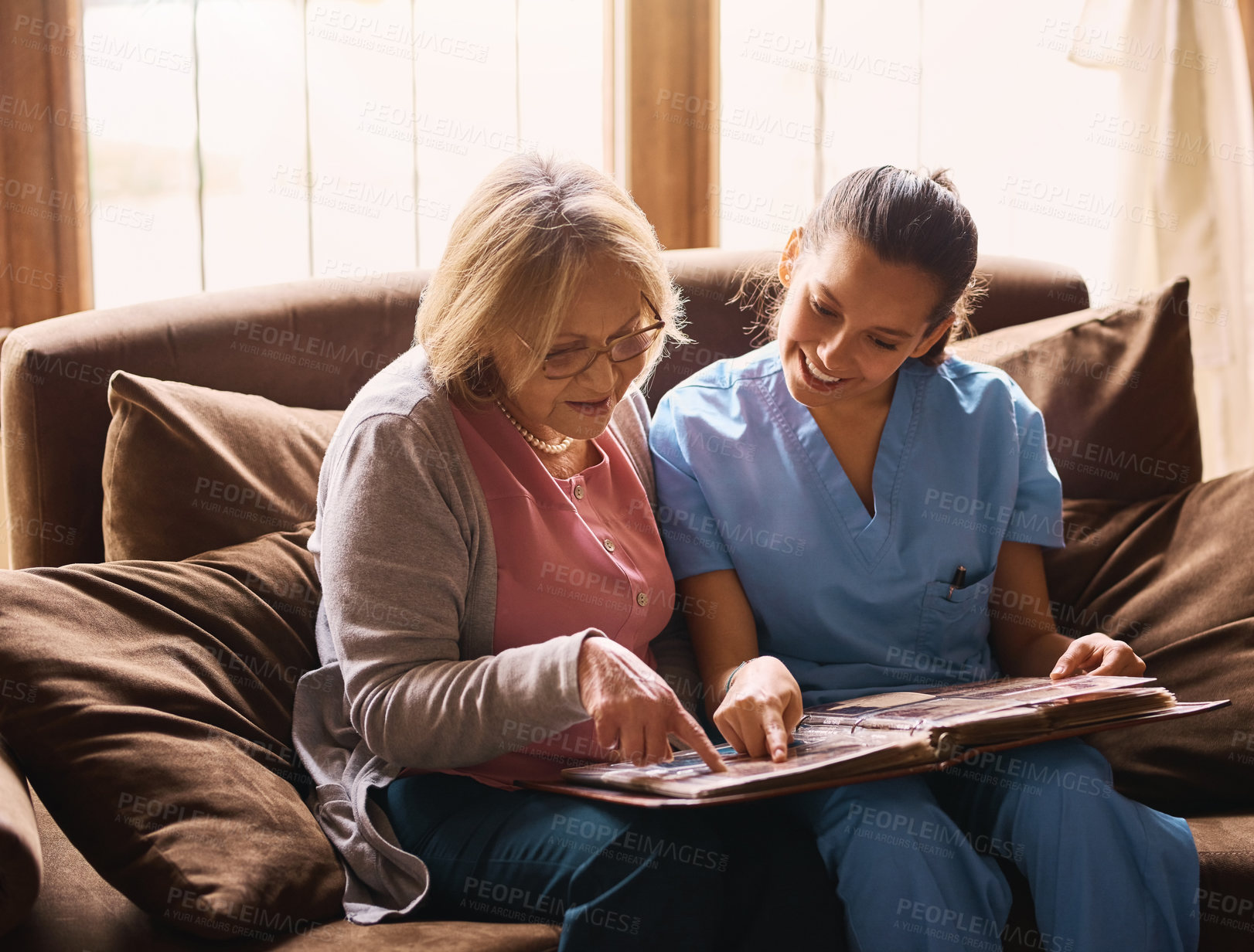 Buy stock photo Elderly, woman and nurse with photo album in home for memories, nostalgia and remember with support. Senior, person or female caregiver in assisted living with talking of pictures, empathy or bonding