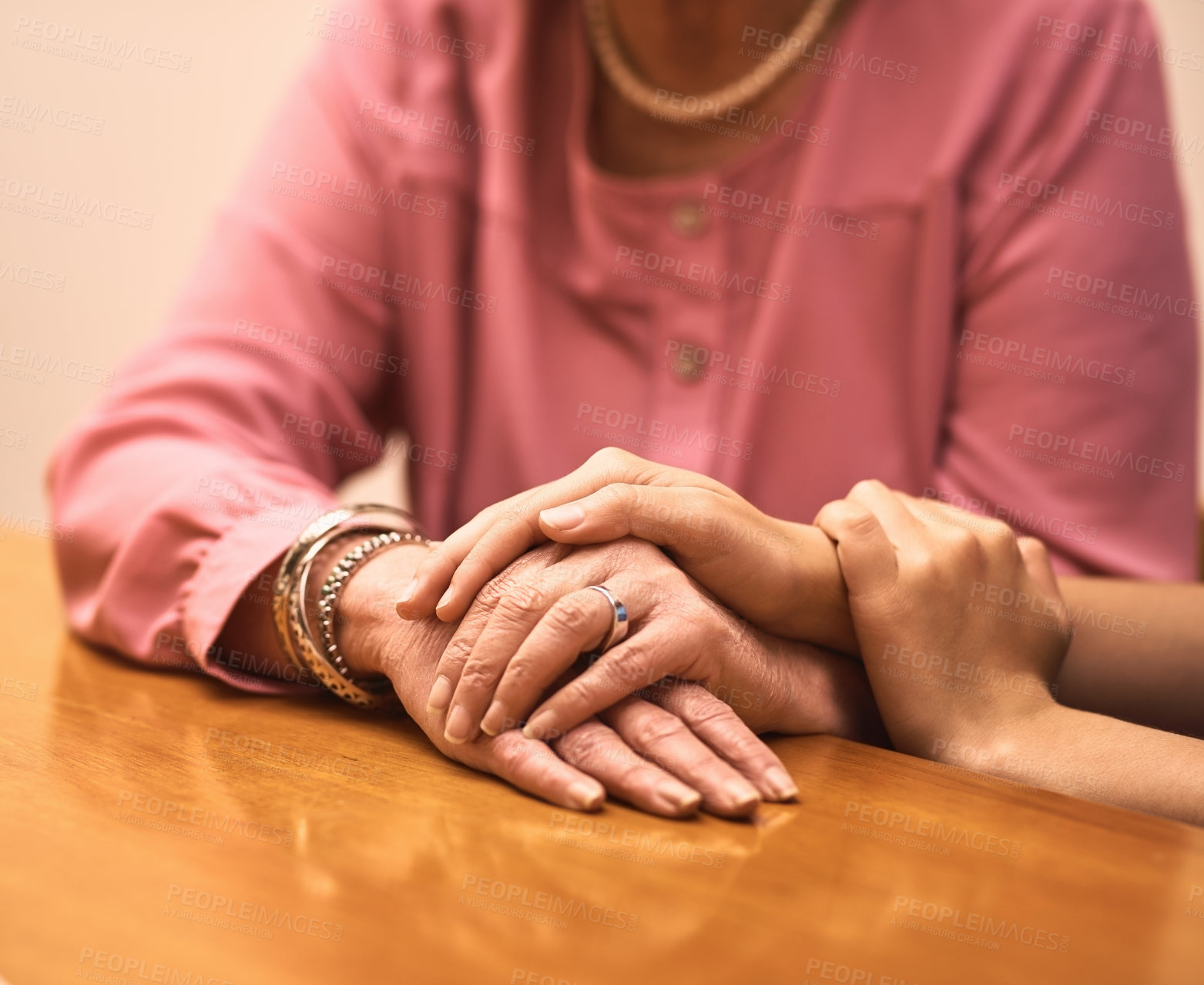 Buy stock photo Comfort, love and hands of people on table for empathy, compassion and support in hope together. Home, trust and women with gesture of solidarity on desk for kindness, understanding and forgiveness