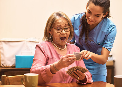 Buy stock photo Shot of a female nurse teaching her patient how to play a card game