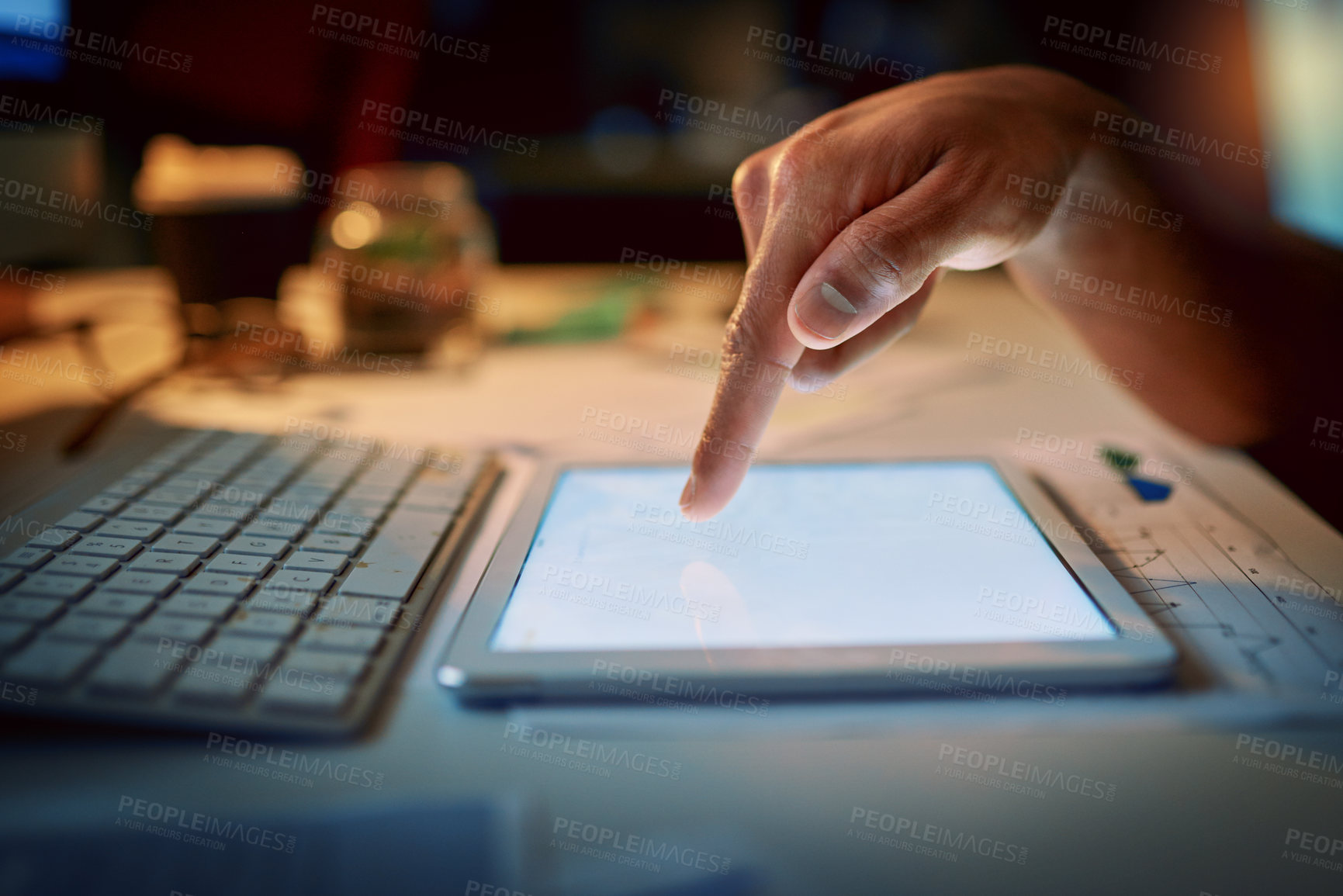 Buy stock photo Cropped shot of an unrecognizable man using a digital tablet during a late night at work