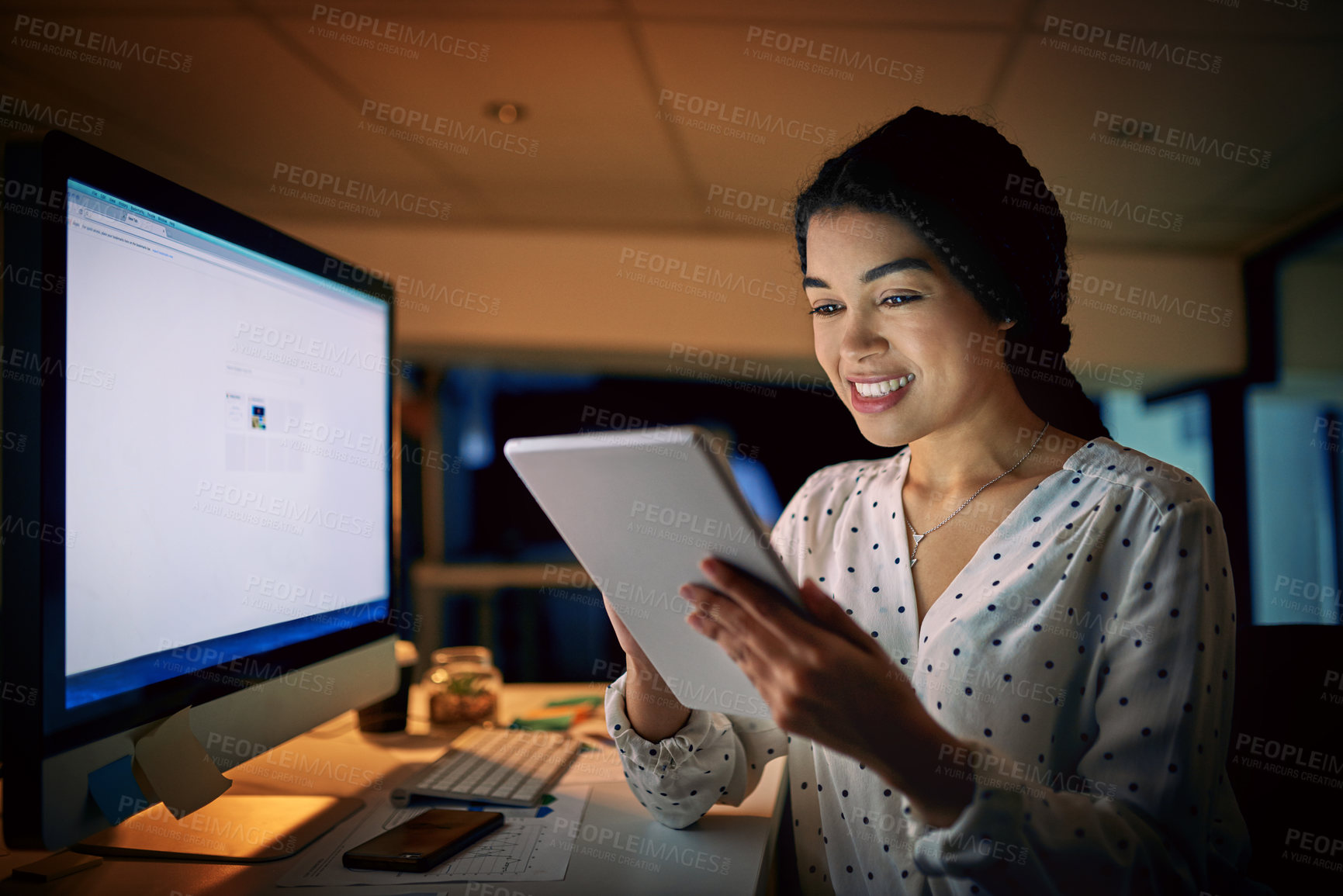 Buy stock photo Shot of a young businesswoman using a digital tablet during a late night at work