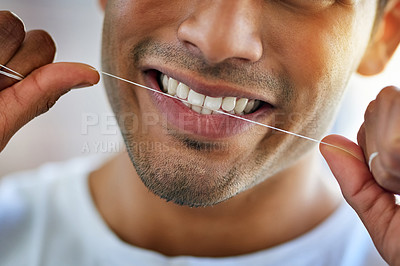 Buy stock photo Cropped shot of a happy young man flossing his teeth at home