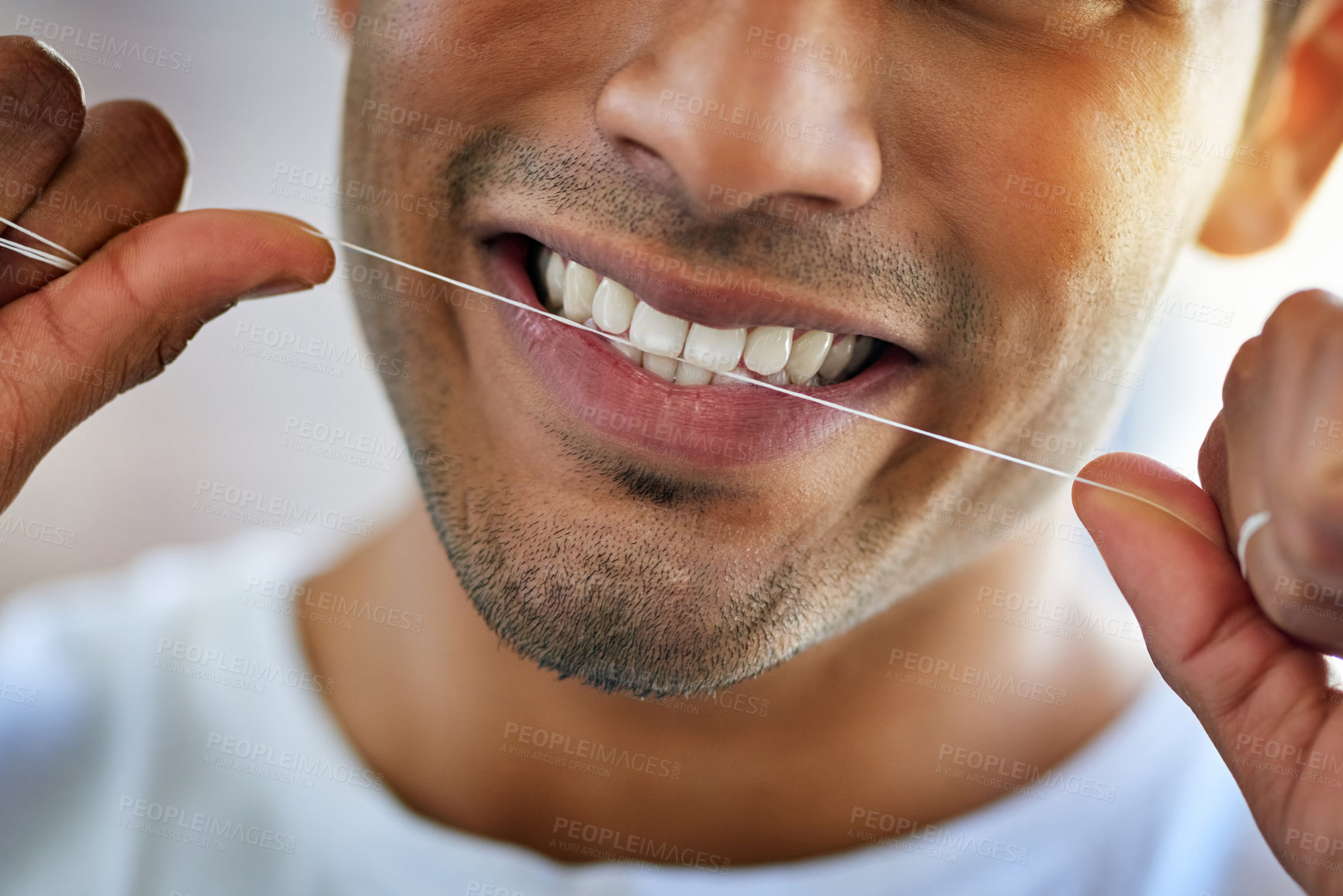 Buy stock photo Cropped shot of a happy young man flossing his teeth at home
