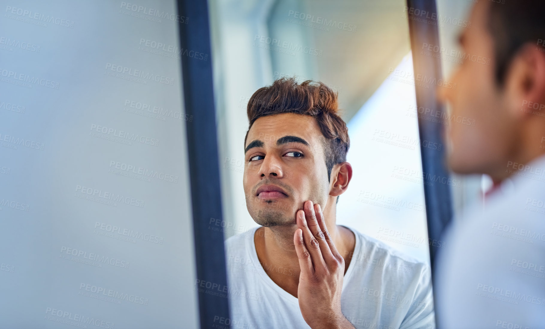 Buy stock photo Skincare, man looking in a mirror and face in bathroom with lens flare. Body treatment or cosmetics for wellness, dermatology or skin routine and facial care with male person at home in morning