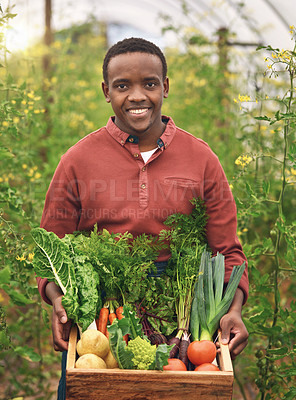 Buy stock photo Cropped portrait of a handsome young male farmer carrying a crate of fresh produce