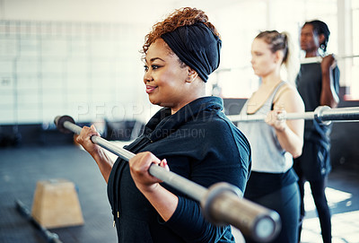 Buy stock photo Shot of a fitness group using steel bars in their session at the gym