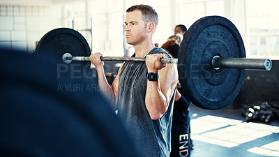 Buy stock photo Shot of a man working out with a barbell in his session at the gym