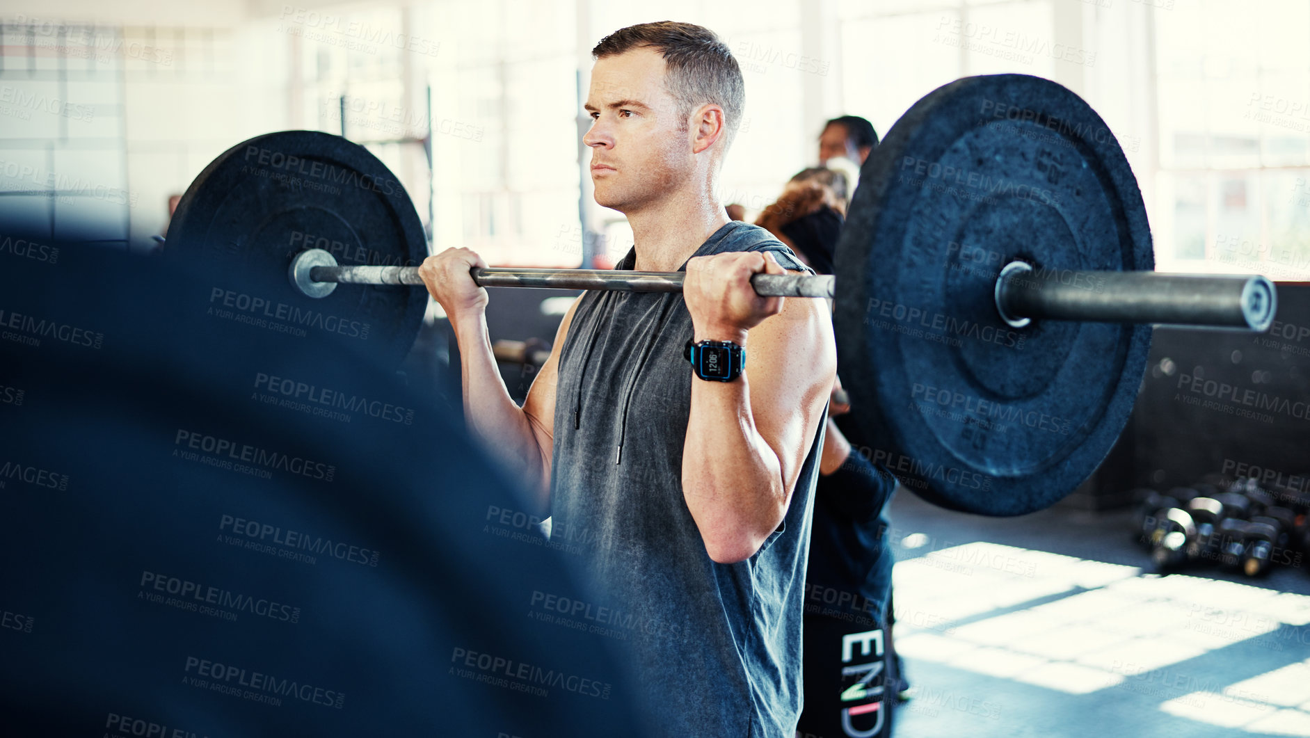 Buy stock photo Shot of a man working out with a barbell in his session at the gym