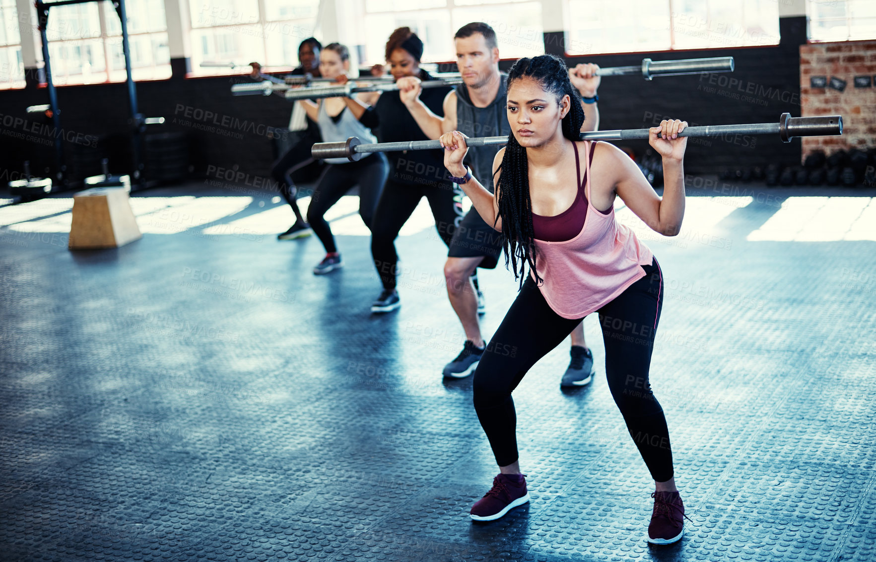 Buy stock photo Shot of a fitness group using steel bars in their session at the gym