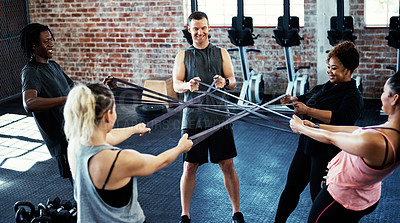 Buy stock photo Shot of a fitness group working out with resistance bands in their session at the gym