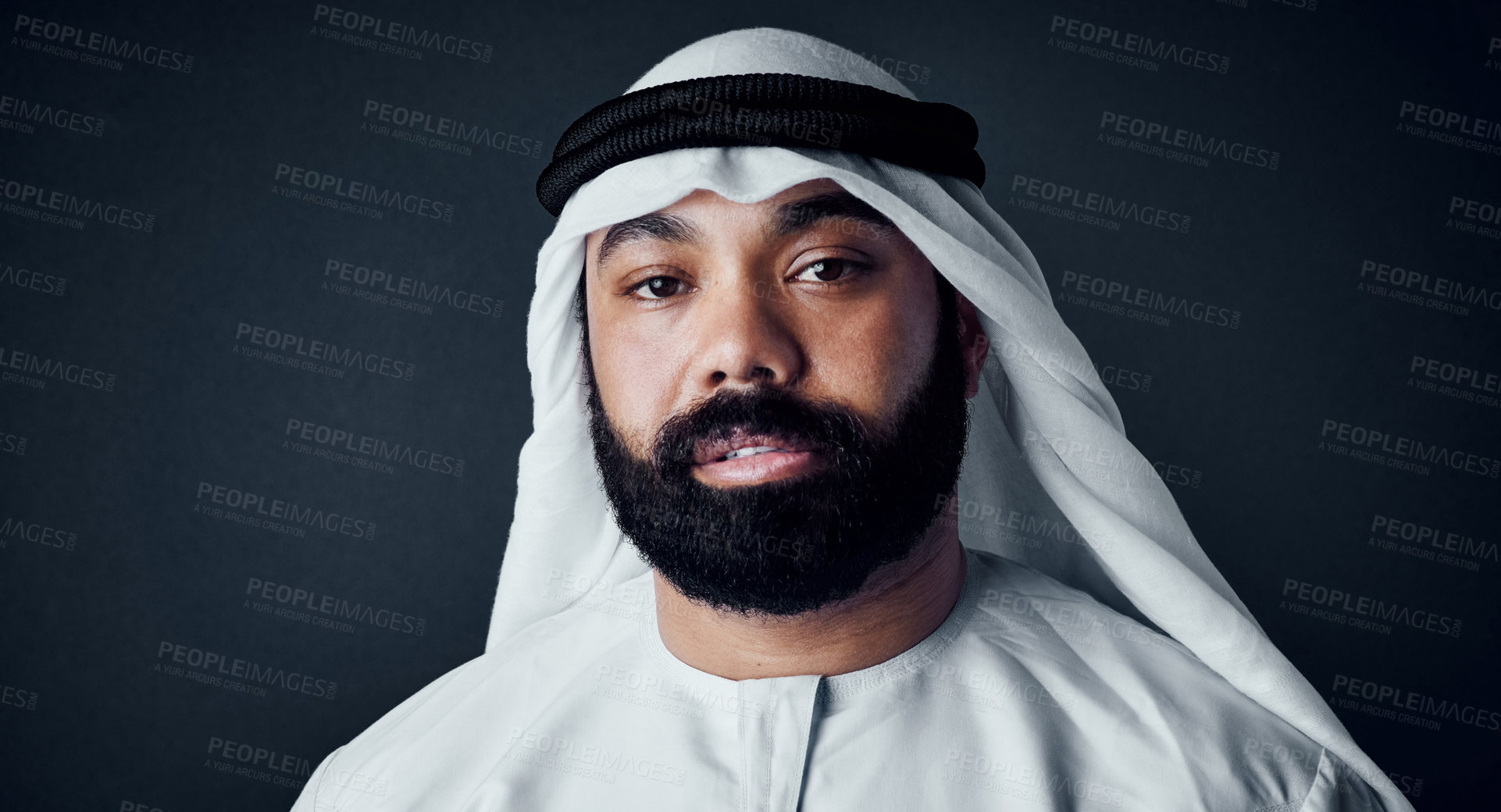 Buy stock photo Studio shot of a young man dressed in Islamic traditional clothing posing against a dark background